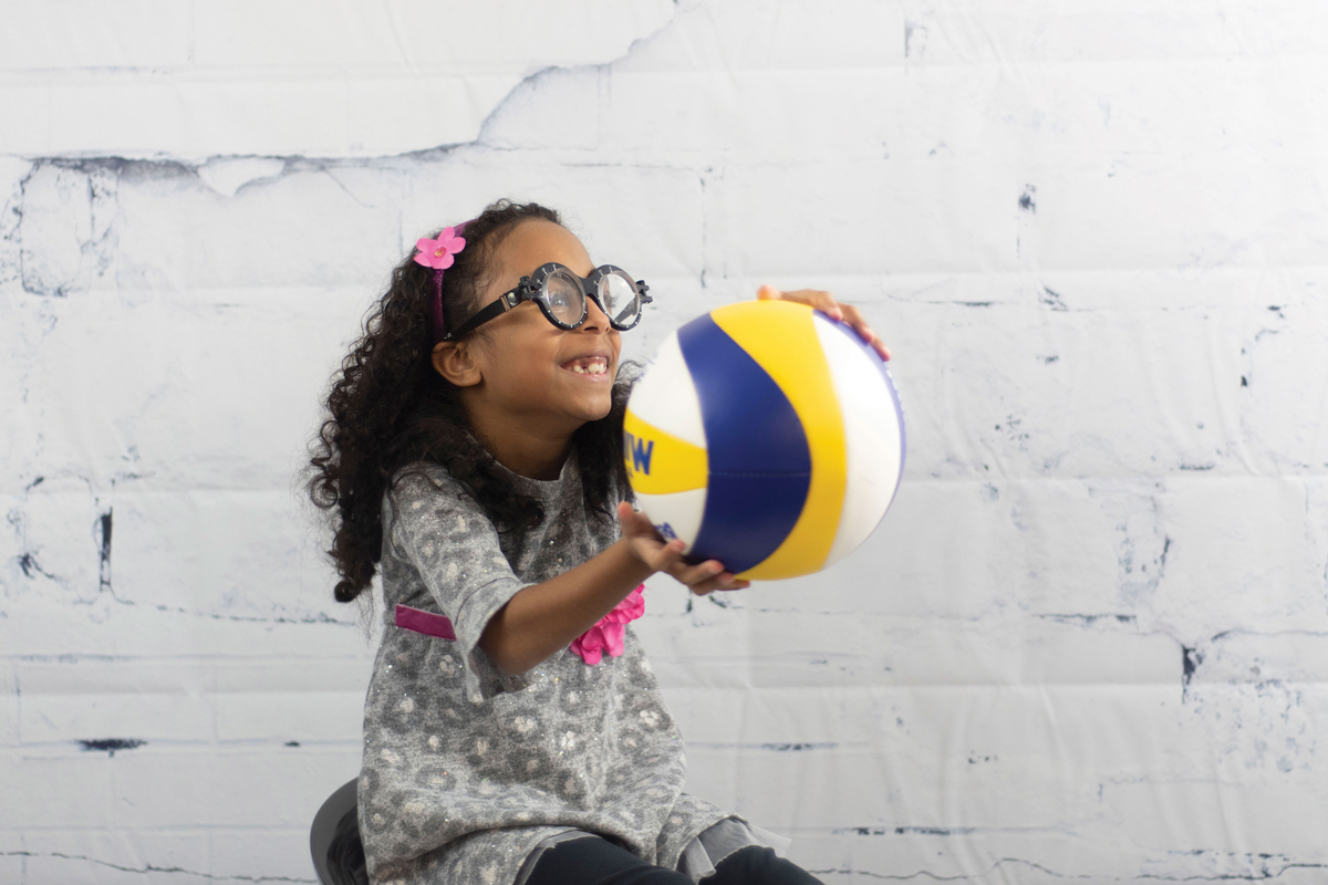 The patient, while wearing base-up yoked prisms, catches a ball during a visual performance assessment.