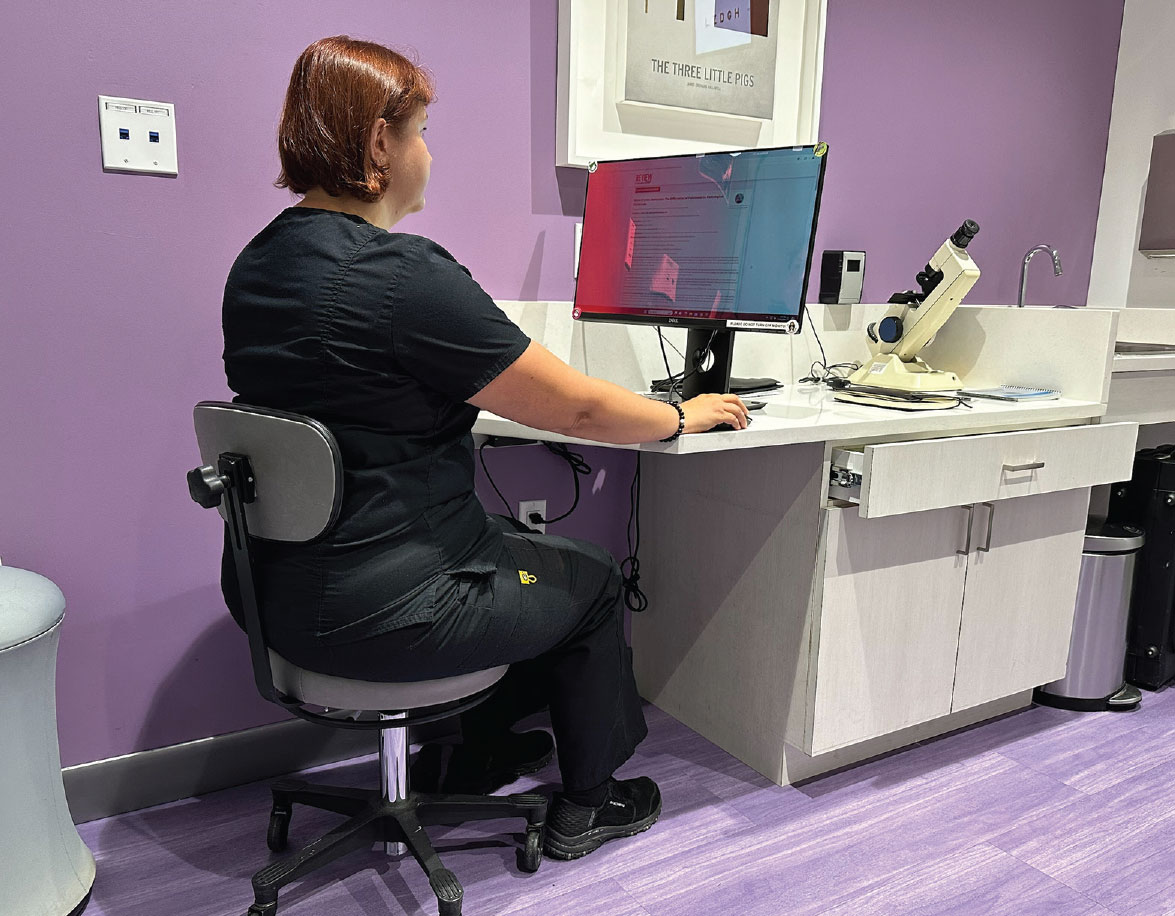 Teach patients about the proper ergonomic positioning needed during extended computer use. In this photo, you can also see the placement of stickers at each corner of the screen to help promote peripheral awareness and prevent over-accommodation.